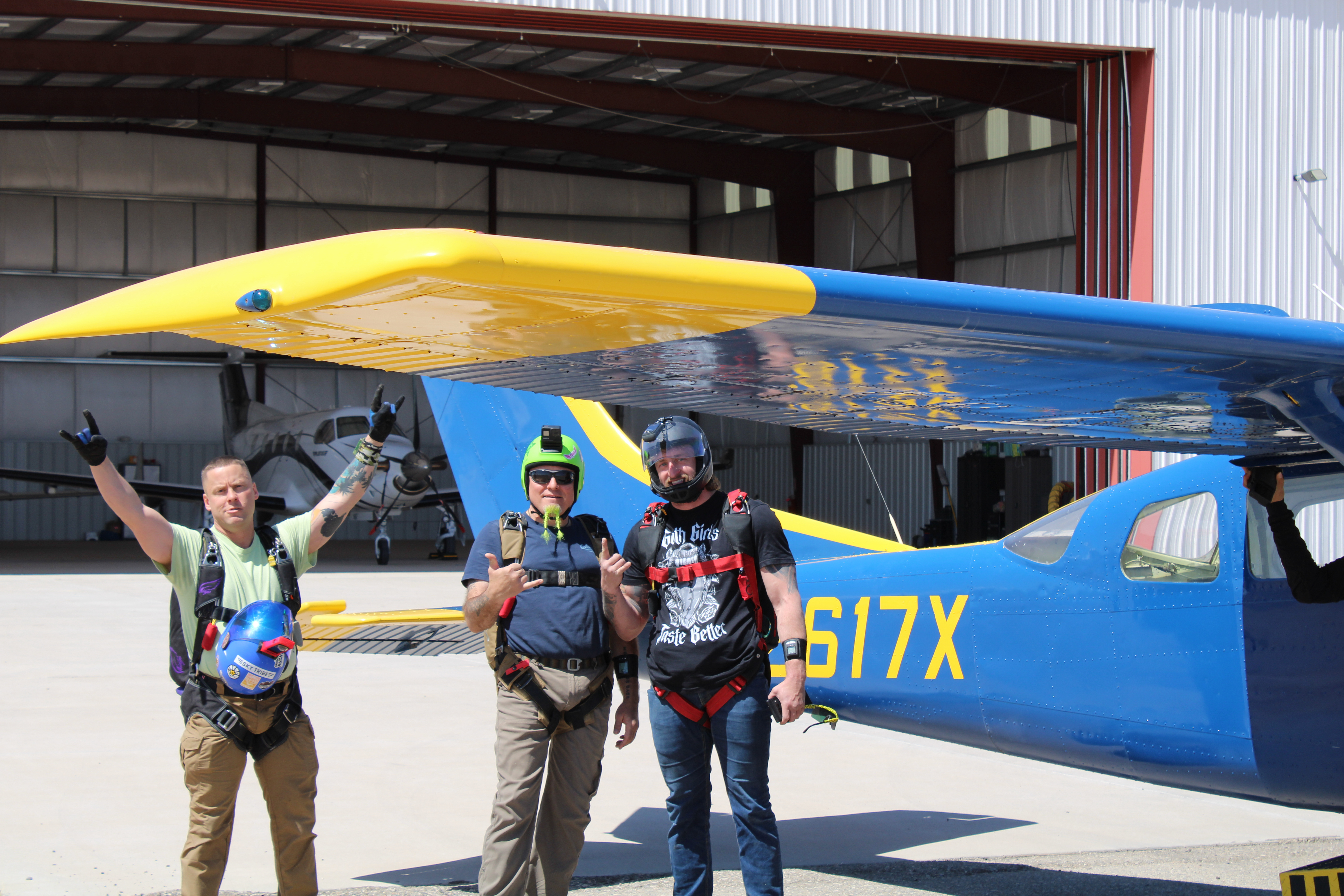 Smiling man waving at camera under canopy